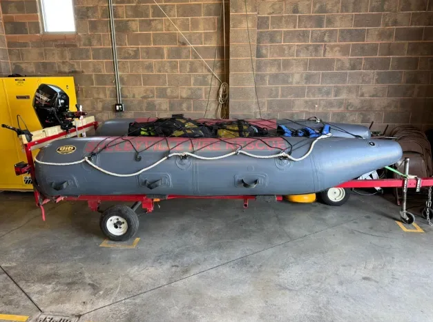 Indoor boat hull wiring with control module and cables on workshop trailer, detailed installation view.