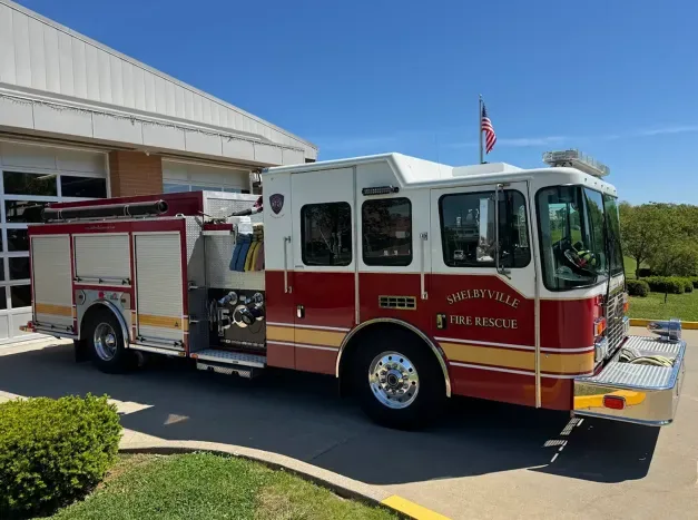 2013 Ferrara Intruder fire truck with American flag parked at fire station, white and red E32